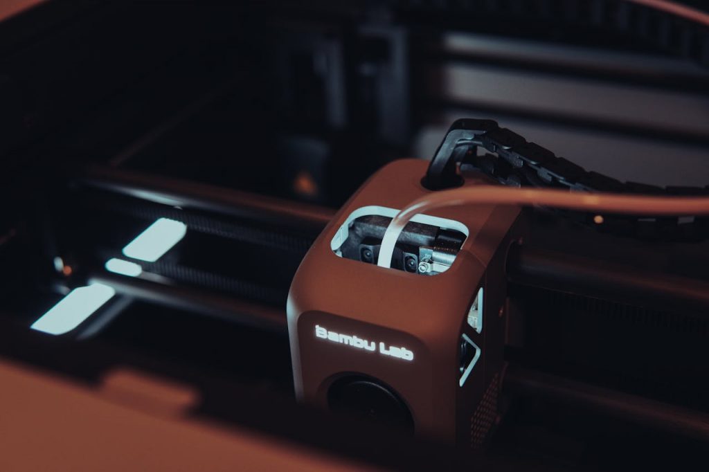 pexels photo 15584332 Detailed view of a 3D printer mechanism in a dark setting, highlighting technology.